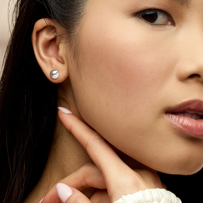 Sterling silver 8mm ball stud earrings on ear, polished round discs