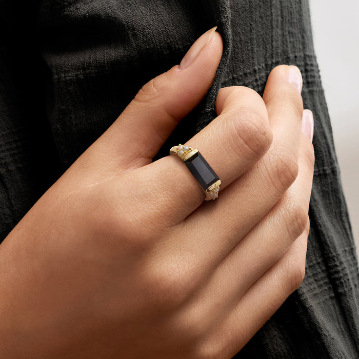 Gold onyx ring with rectangular black stone and small pearl settings on band